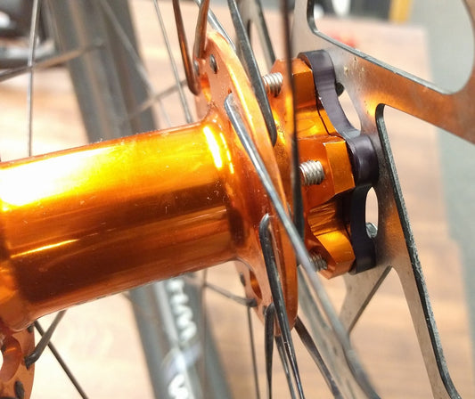 A closeup view of a gold colored front bike hub